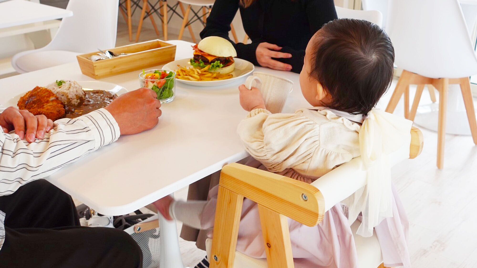 A dining table with various dishes, including sushi, a burger, and a salad.