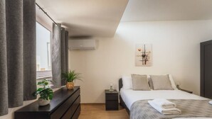 Ein modernes Schlafzimmer mit Bett, Nachttisch und Kommode.