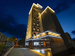 Un hotel de varios pisos con un llamativo cartel en la planta baja.