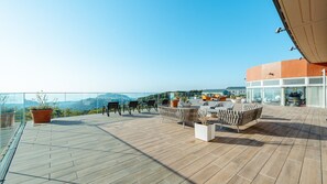 A rooftop terrace with wooden flooring, outdoor seating, and potted plants. - Lectore Hayama Shonan Kokusai Mura (Hayama)