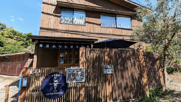 Un edificio de madera con un letrero que dice "Coffee Princess" y una pizarra de menú.