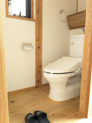A small, wooden-framed bathroom with a white toilet, a toilet paper holder, and a TOTO brand toilet. - Arima Villa Kinoie (Kobe)
