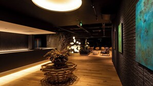 A modern interior with a reception desk, wooden flooring, and a unique geometric planter. - Etchu Goi Hanao Onsen Yamaboushi (Takaoka)