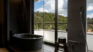 A bathroom with a stone basin, a shower, and a view of a forested hillside. - Etchu Goi Hanao Onsen Yamaboushi (Takaoka)