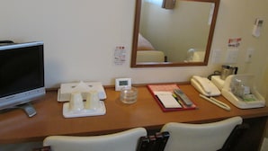 A hotel room desk with a television, a mirror, a telephone, and a small table with toiletries. - Business Hotel Step In Haramachi (Minamisoma)
