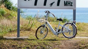 A sign with '77.7 MHz' and a bicycle parked in front. - Villa Tsumugu (Izumo)