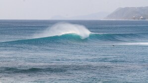 A large wave in the ocean with a surfer riding it. - Villa Tsumugu (Izumo)