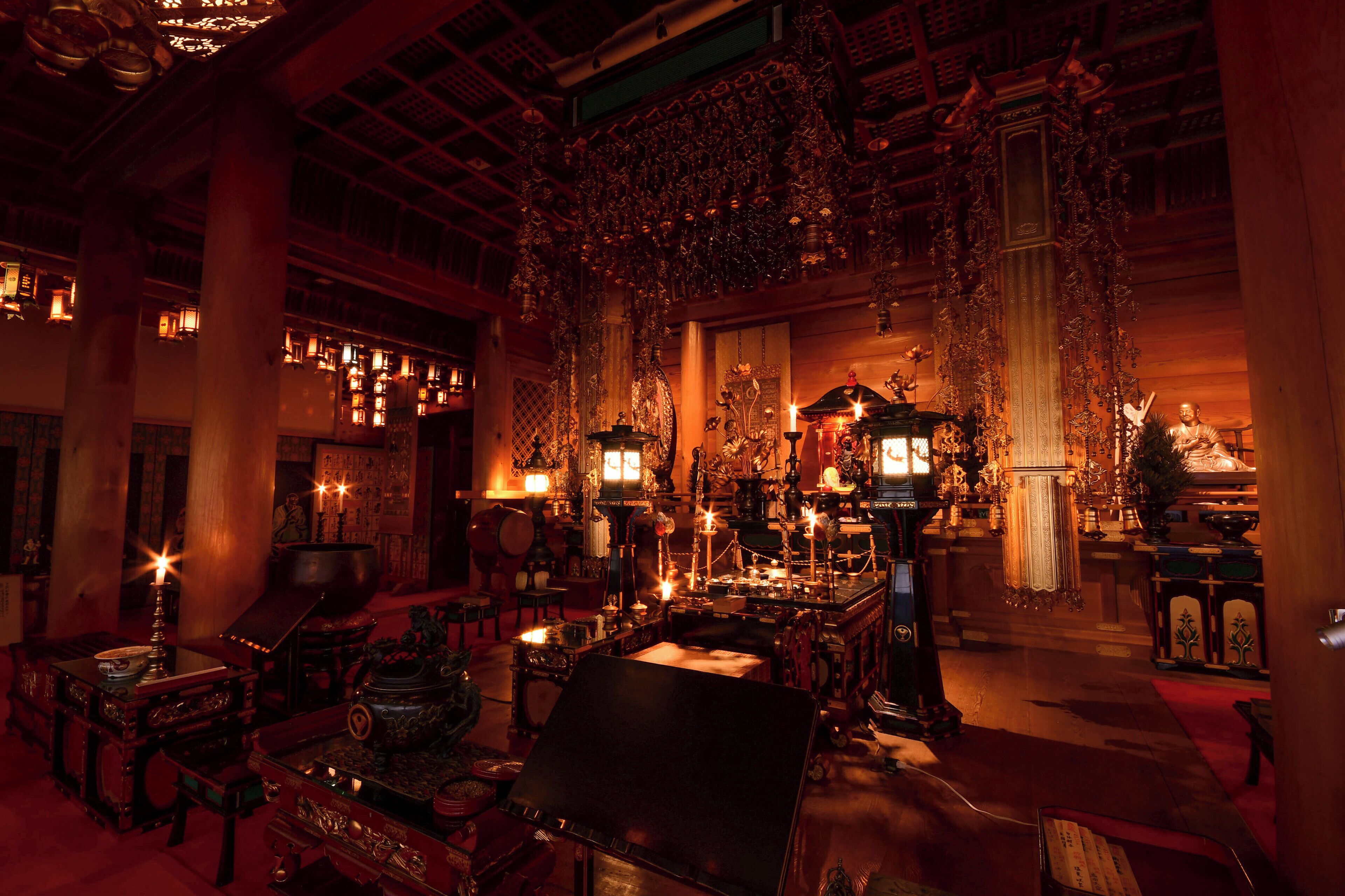 Un interior ornamentado con decoración tradicional, que incluye un gran altar, adornos colgantes y una mesa central.