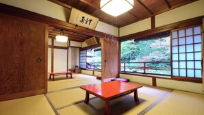 Una habitación japonesa tradicional con suelo de tatami, una mesa de madera y una puerta corredera.