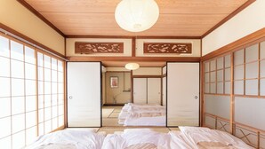 Une pièce de style japonais traditionnel, avec un sol recouvert de tatamis, des portes coulissantes et un plafond bas.