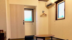 Une pièce avec des tatamis, une table et deux chaises.