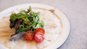 Une assiette contenant une salade composée de feuilles de salade et de tomates en tranches.