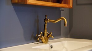 A bathroom sink with a gold faucet and a white basin. - Kurashi no Yado Temari Madoromi (Kurashiki)