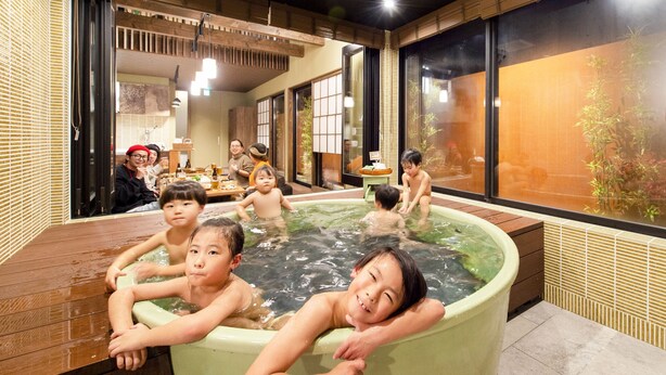 Un baño tradicional japonés con suelo de madera y paredes de esteras de tatami.