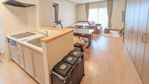 Une chambre d’hôtel compacte comprenant un coin cuisine, un espace repas, un canapé et une armoire.