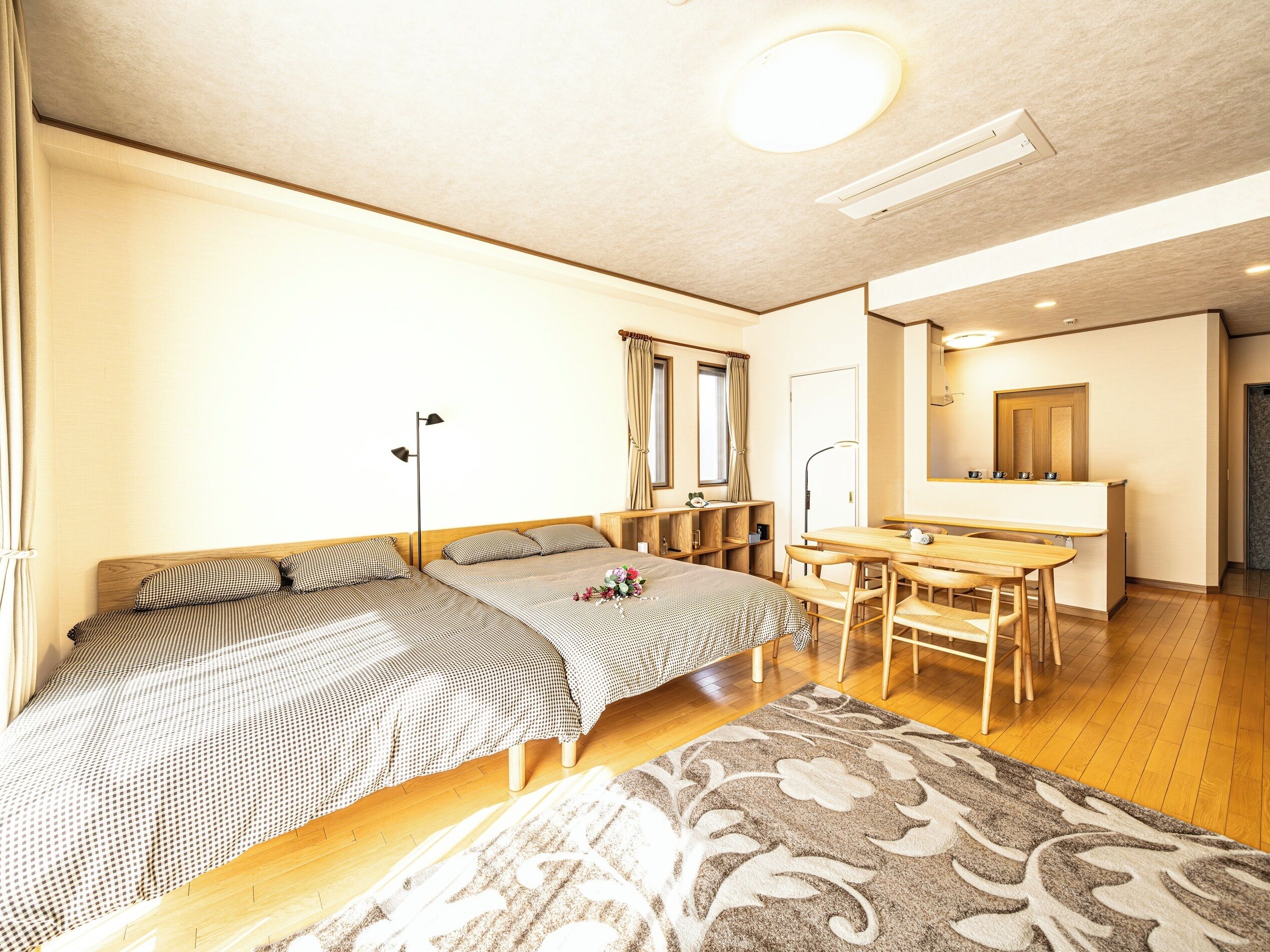 A bedroom with a bed, bedside tables, a desk, and a mirror.