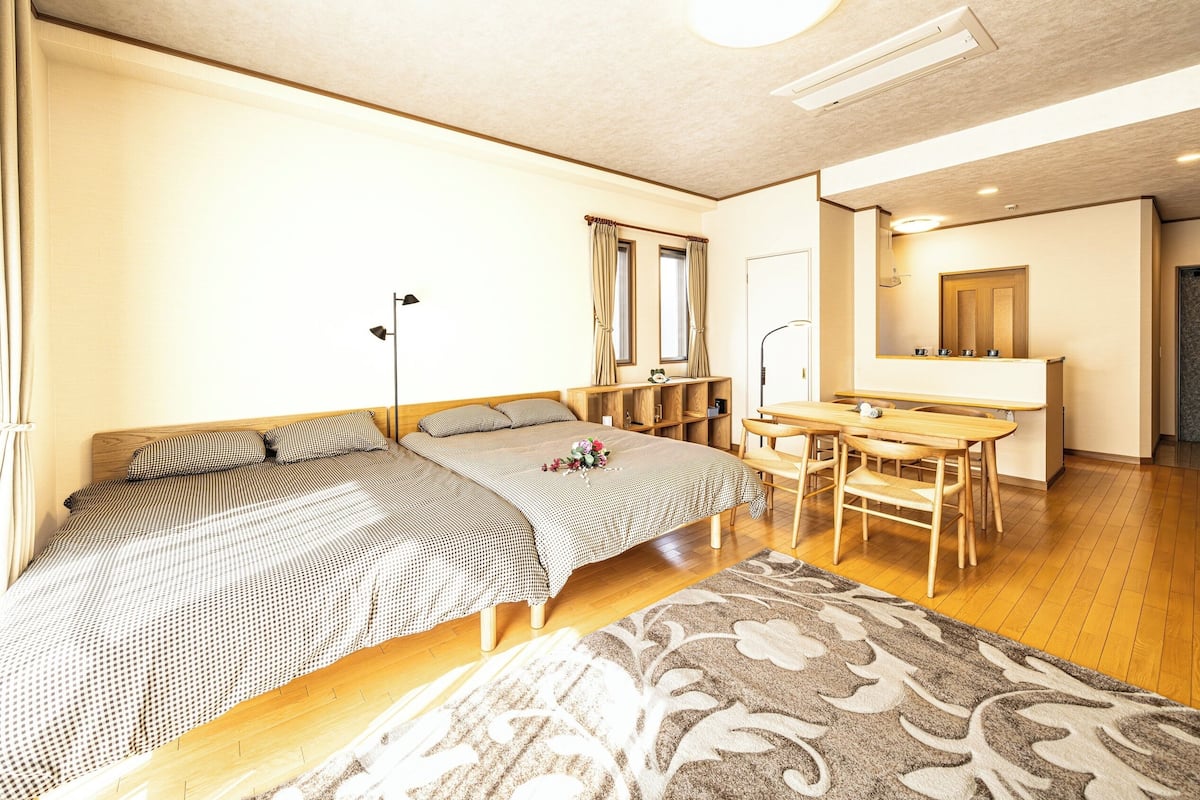 A bedroom with a bed, bedside tables, a desk, and a mirror.