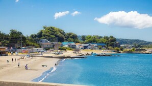 Une plage avec des maisons et un ciel bleu dégagé.