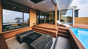 A modern outdoor living area with a pool, seating, and large windows offering views of the sea. - Private Villa Yuhimi ~sunset Hill~ (Aki)