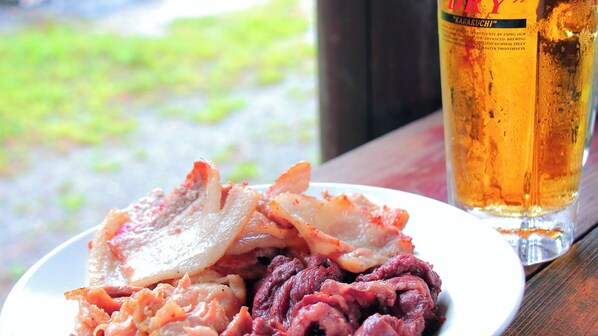 A plate of food and a glass of beer on a table. - Gokase no Sato Campsite & Guesthouse (Gokase)