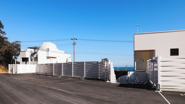 A parking area with a white building and a dome structure in the background. - Coral Resort Villa Atsuhama (Sumoto)