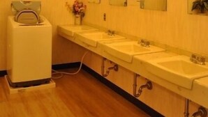 Um banheiro de hotel com várias pias, espelhos e vaso sanitário.