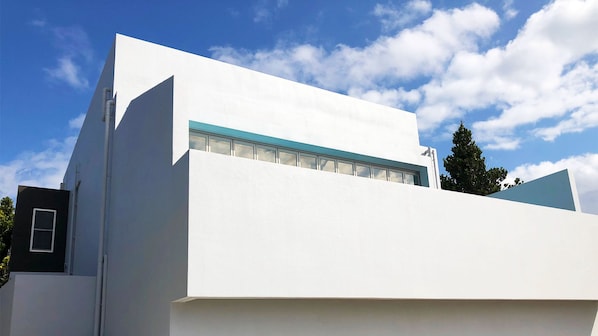 A modern building with a flat roof, large windows, and a prominent corner structure.