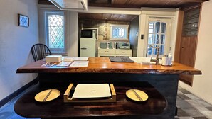 A kitchen with a wooden countertop, a sink, and a window with a view of the outside. - Akiya Cornerstone (Awaji)