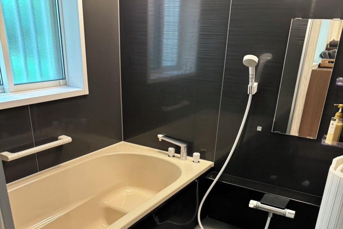 A modern bathroom with a bathtub, a shower, and a toilet.