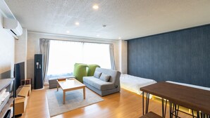 Een moderne woonkamer met een bank, een eettafel en een televisie.