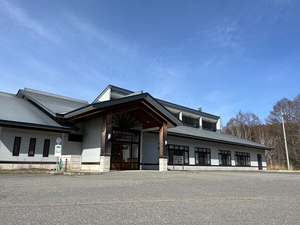 A building with a traditional architectural style, featuring a prominent entrance with a wooden overhang.