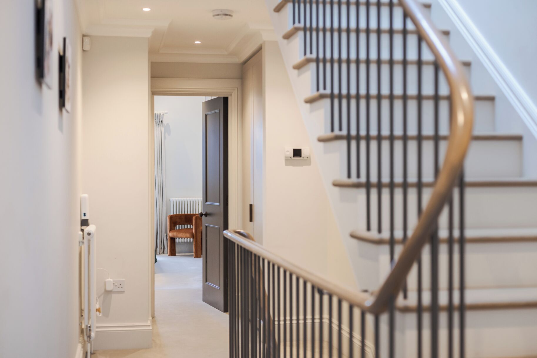 A staircase with a metal handrail leading to a landing.