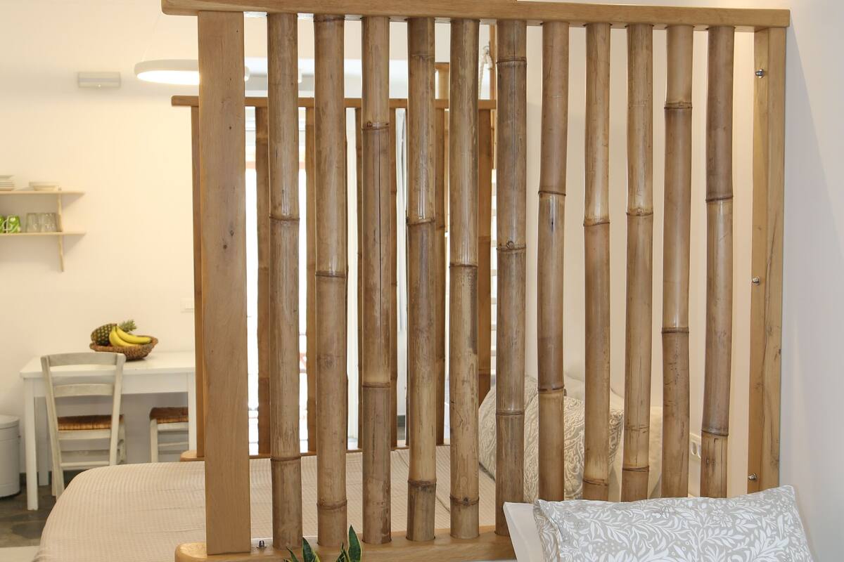 A bedroom with a bed, bedside table, and a wooden partition.
