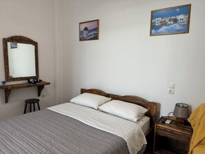 A bedroom with a bed, a nightstand, a lamp, and two framed pictures on the wall. - Anais Anais Mykonos (Mykonos)