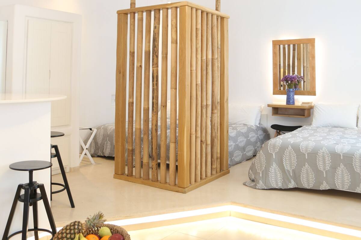 A modern bedroom with a bed, bedside table, and a wooden partition.