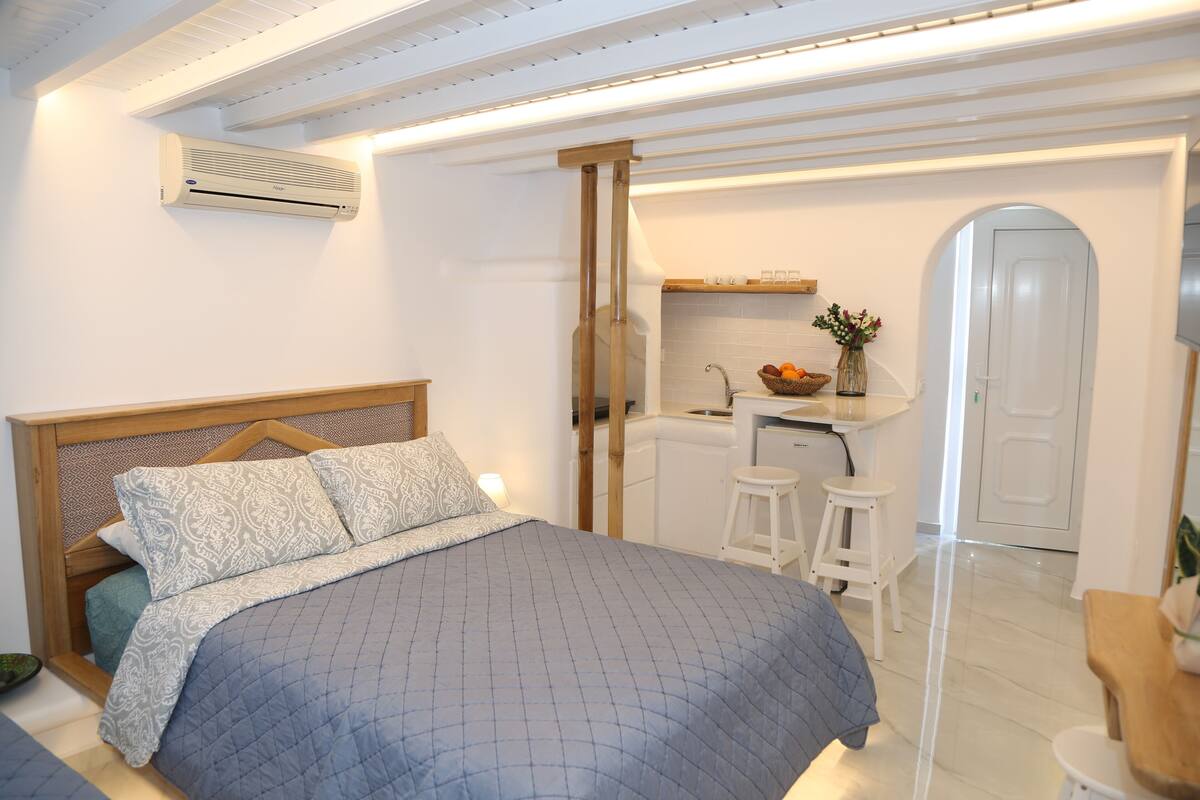 A bedroom with a bed, a wooden headboard, a bedside table, and a nightstand.