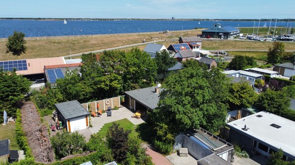 Ein Wohngebiet mit Häusern, Solaranlagen und einem Yachthafen mit Segelbooten.