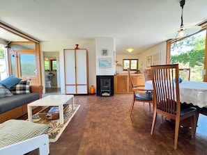 Ein gemütliches Wohnzimmer mit Sofa, Esstisch und Kamin.