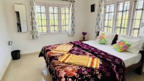 Une chambre à coucher avec un lit, une chaise et une fenêtre.
