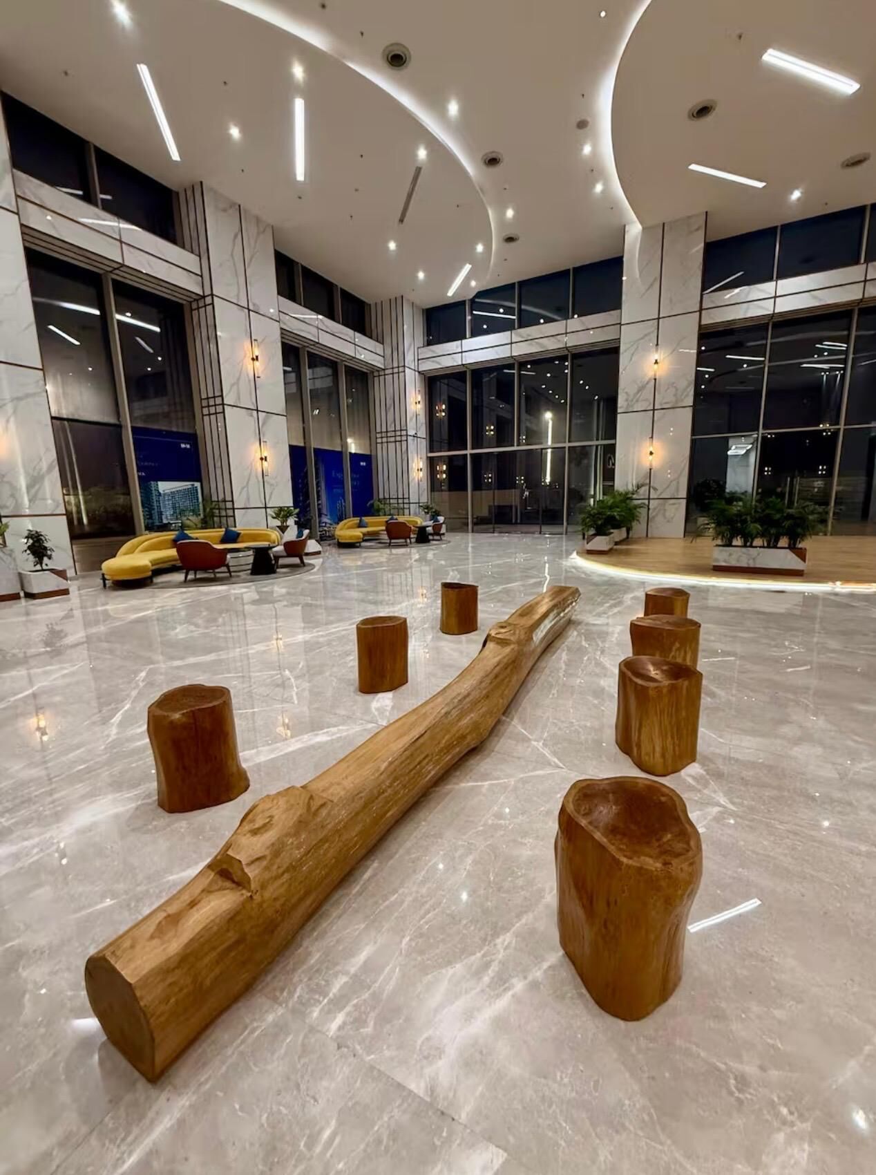 A spacious lobby with a marble floor, modern seating, and large windows offering views of the cityscape.