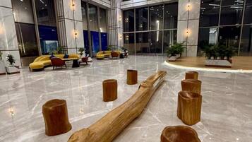 A spacious lobby with a marble floor, modern seating, and large windows offering views of the cityscape.