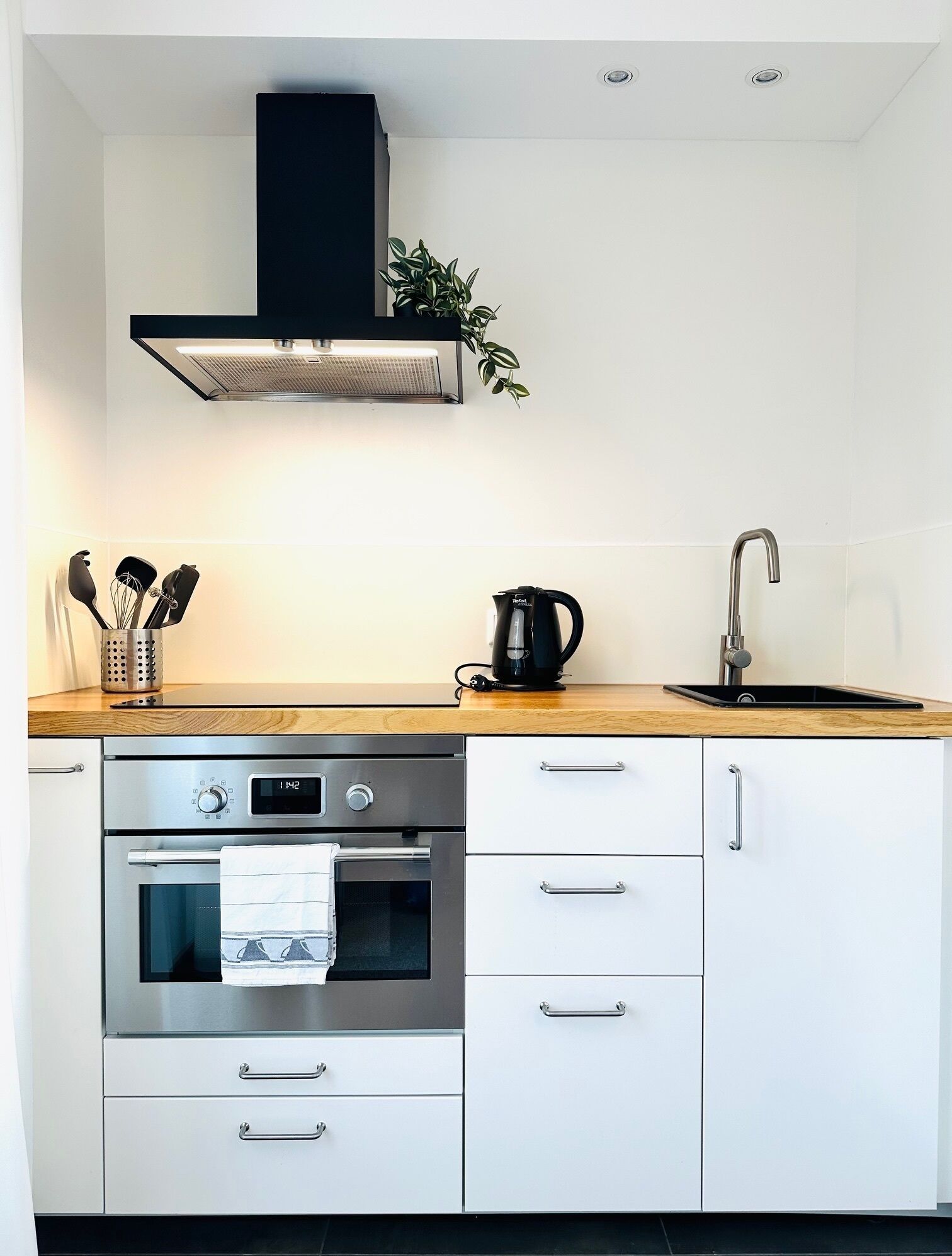 A modern kitchen with a stainless steel range, oven, and built-in dishwasher.
