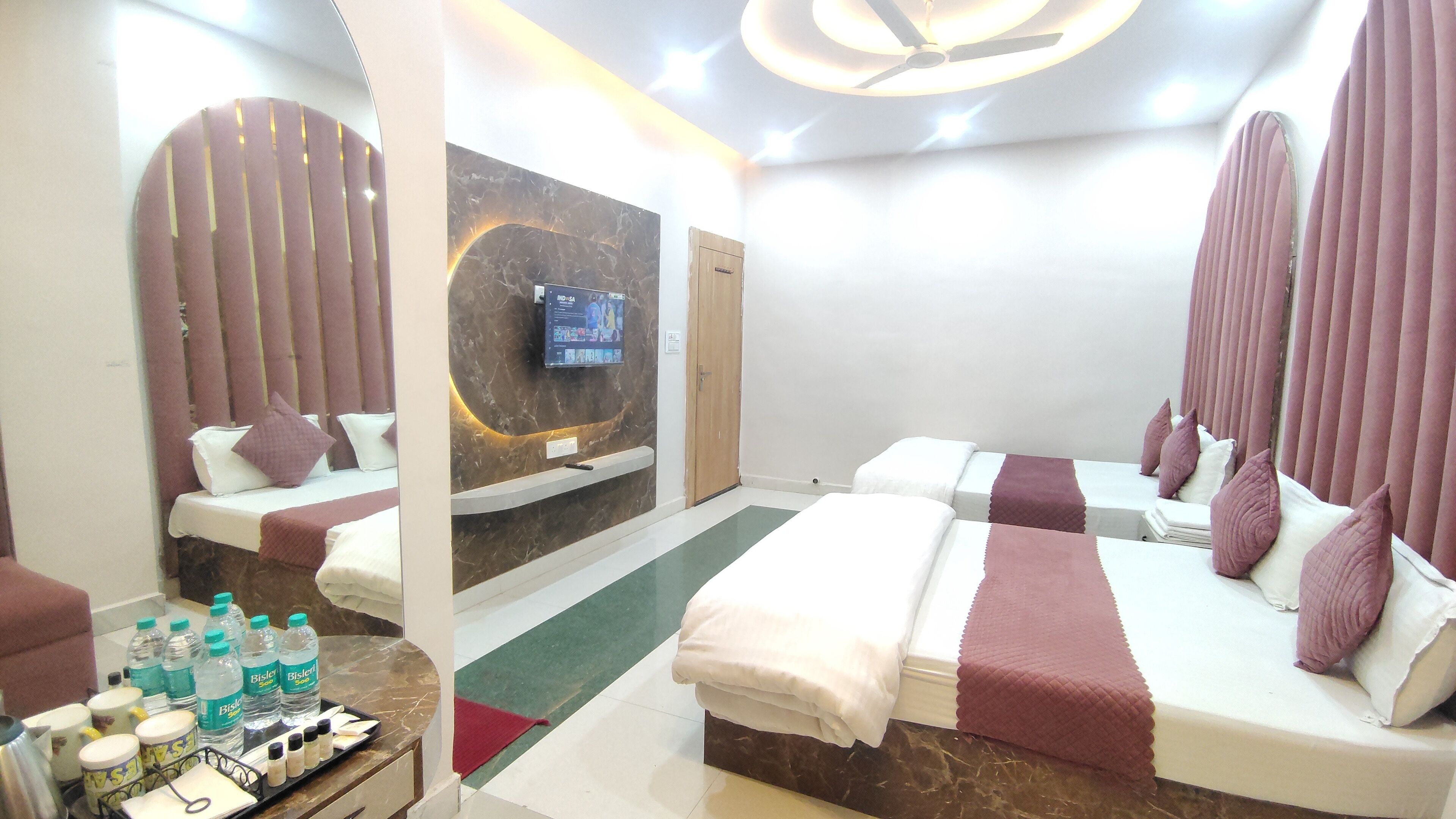 A hotel room with two beds, a TV, and a minibar.