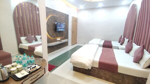 Habitación de hotel con dos camas, televisor, minibar y baño.