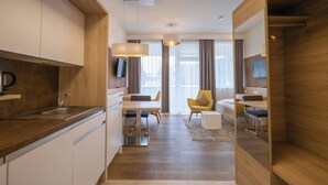 Una habitación de hotel moderna con cocina, comedor y sala de estar.