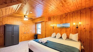 Une chambre aux murs lambrés, avec un lit, une armoire et une fenêtre.