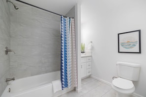 Un baño con ducha, inodoro y lavamanos.