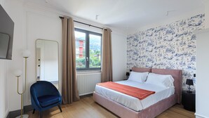 Et soveværelse med en stor seng, en stol, en gulvlampe, en radiator og et vindue med gardiner.