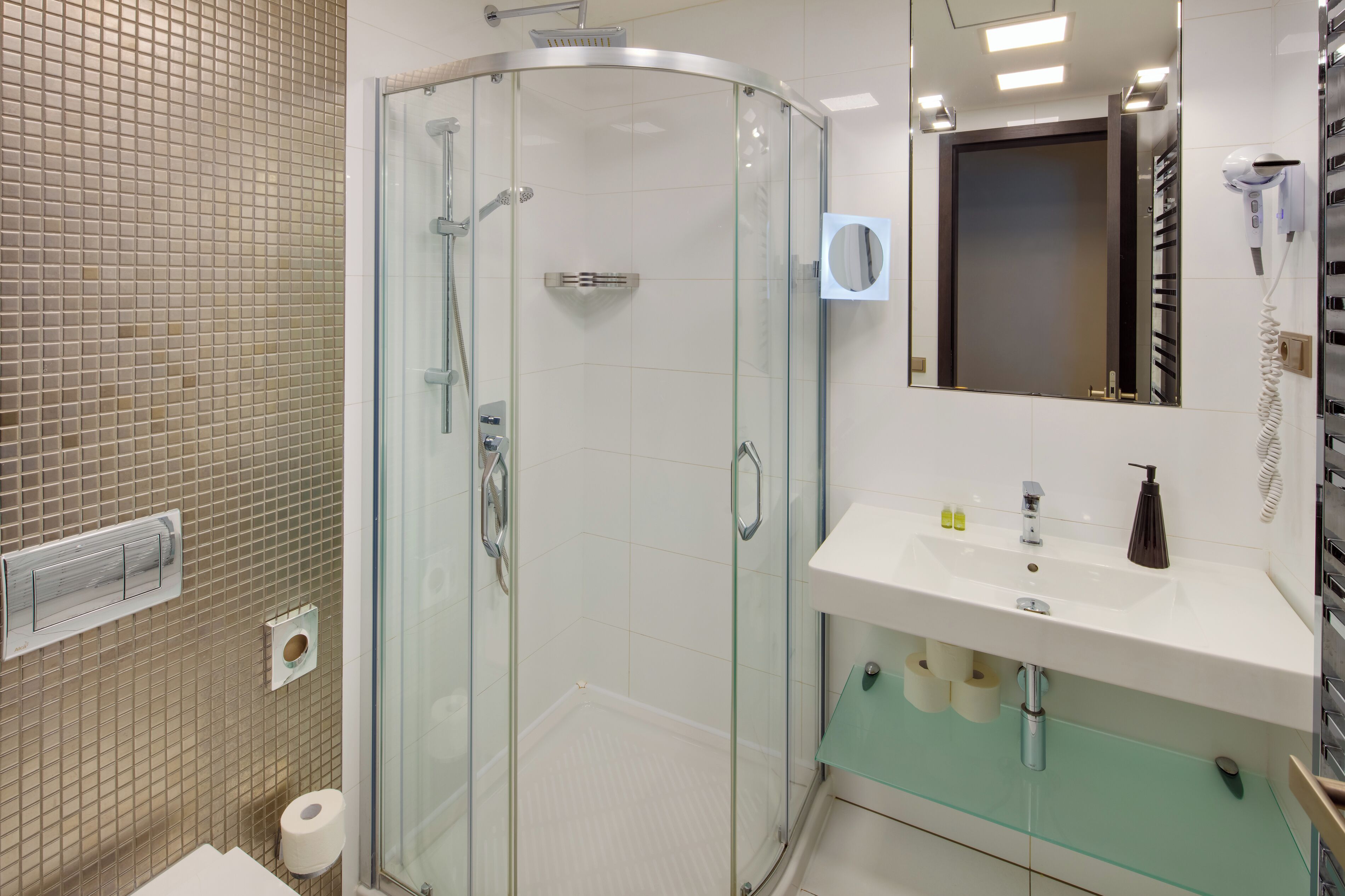 Ein Badezimmer mit Duschkabine aus Glas, einem weißen Waschbecken mit Spiegel und einem Handtuchhalter.