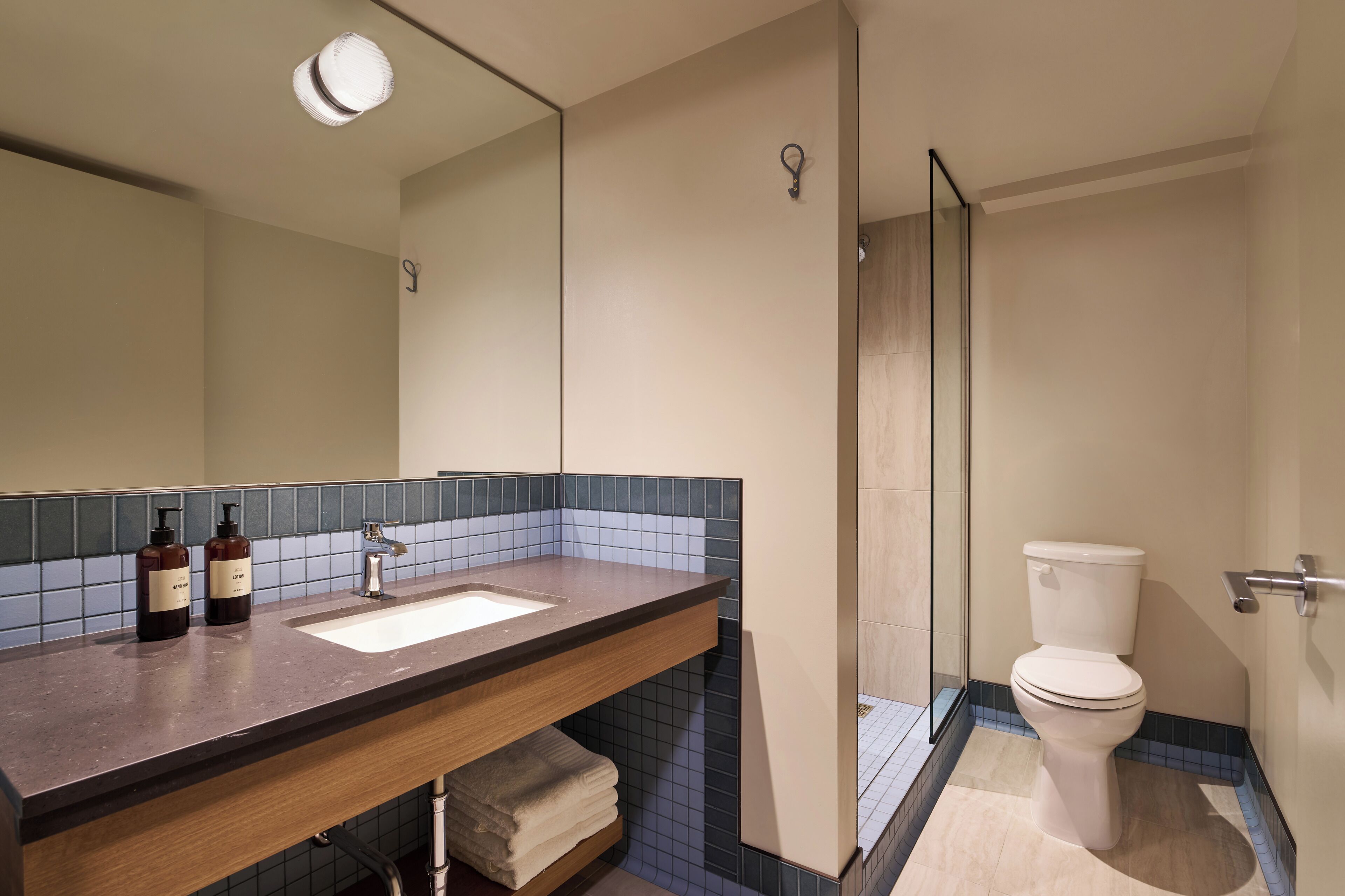 Un bany amb un lavabo, un mirall i un vàter.
